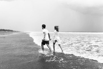 Happy couple running on the beach