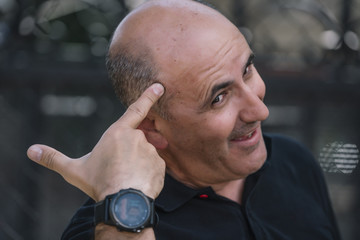 Bald man shows his funny head.