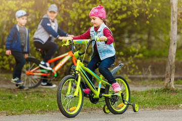 Naklejka na ściany i meble Smiling little girl on a bicycle.