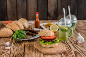 Tasty hamburger with meat and vegetables against a dark background. Fast food. It can be used as a background