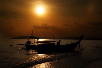 Fototapeta na wymiar traditional thai longtail boat silhouette at sunset