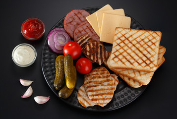 Ingredients for a sandwich on a black background.