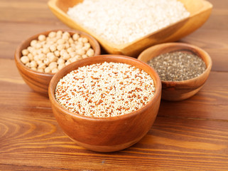 Healthy super food - dry chickpeas, quinoa, chia on brown wooden background, side view
