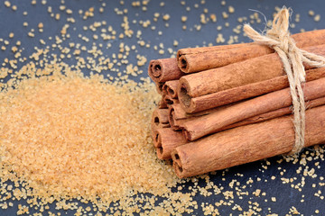 Cinnamon sticks with brown sugar on slate