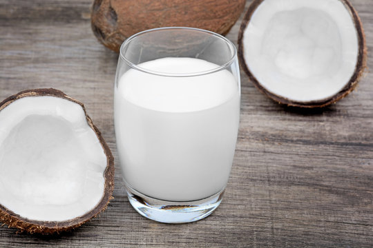 Coconut milk in a glass on old wood table