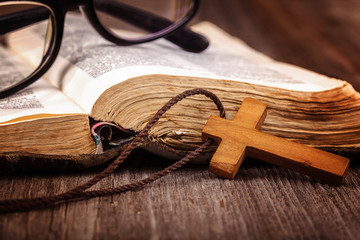 Ancient holy book of a wooden cross on a cord.