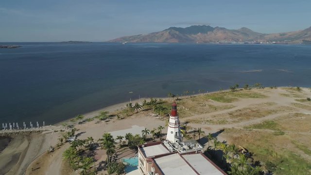 Coastline with beach and lighthouse, mountains. Aerial view: Coast sea with hotels, resorts, Subic Bay, Philippines, Luzon