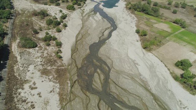 Parched mountain river river among the farm fields in the mountainous province Philippines, Luzon.Drought. Aerial view: relief of mountain valley with river.