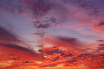 Naklejka na ściany i meble The crimson sunset and amazing clouds in the sky.