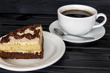 a piece of cake in a plate with a cup of coffee