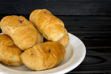 Croissants in a plate on a black wooden background