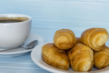 cup of coffee with croissants  on a blue tree background