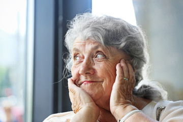 Thoughtful and looking elderly woman face