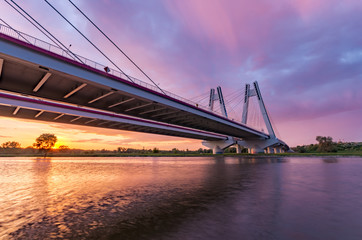 Fototapeta na wymiar Cable stayed bridge over Vistula river, Krakow, Poland, beautiful colorful sunset