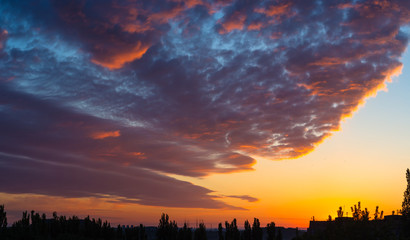 Landscape with dramatic light - beautiful golden sunset with saturated sky and clouds.