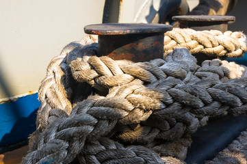 Fototapeta na wymiar Old braided rope on the wooden deck of a sea boat