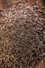 close up of heap of cumin on wood table
