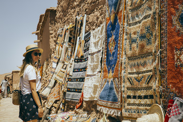Girl at marketplace staring arabic carpets