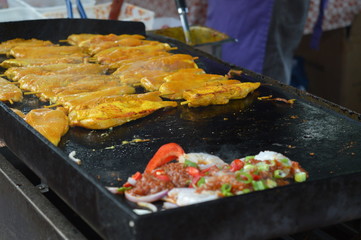 Fresh chicken in Satay style marinade and prawns are fried on a hot plate. 