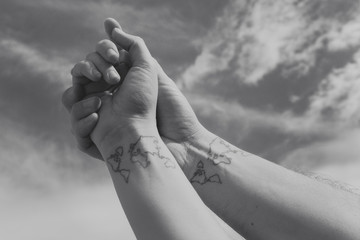 Boy and Girl holding hands with the same tattoo
