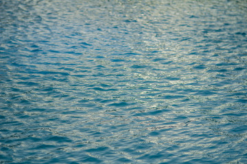 small waves and ripples on the blue water of the swimming pool