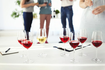Glasses with delicious wine and blurred people on background