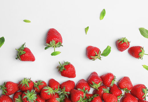 Composition with ripe red strawberries and mint on light background