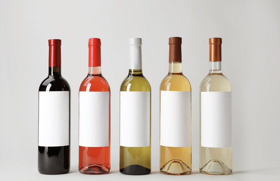 Bottles of delicious wines with blank labels on white background