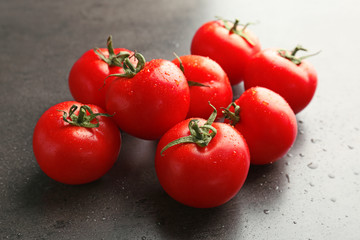 Fresh ripe tomatoes with water drops on grey background