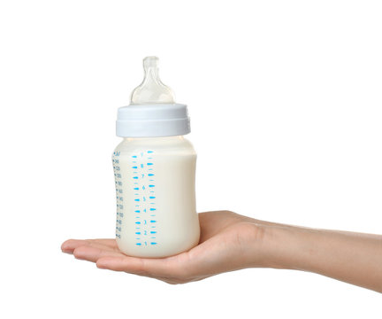 Woman holding baby bottle with milk on white background