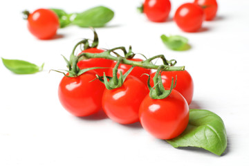 Ripe red tomatoes and basil on table