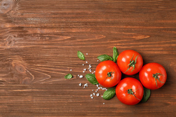 Flat lay composition with tomatoes and basil on wooden background