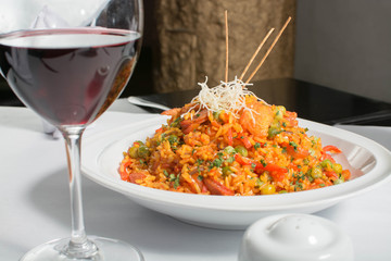 Rice with vegetables and wine over a white plate