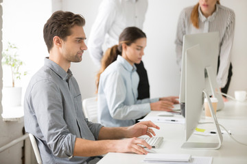 Serious company male worker looking at computer screen, PC user focused on reading online business news, thoughtful employee analyzing financial statistics, or writing email consulting client