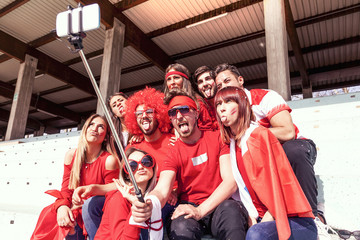Obraz na płótnie Canvas group of fans dressed in red color takes a selfie