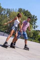 Young couple having fun on roller skates in park