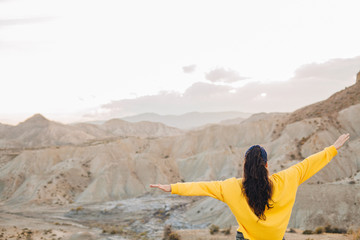Woman feeling free looking at the desert with open arms.