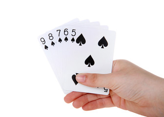 Young female hand holding Playing cards, a straight flush. A straight flush is a five card sequence of the same suit. Spades.