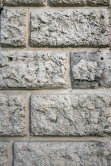 Rough textured plaster wall coating, imitation of stone masonry. Abstract grey patchy background.
