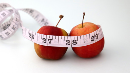 A tape measure indicating two apples and 27 inches.