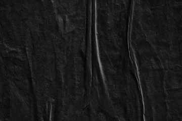 Dark black grey creased crumpled paper background surface old torn ripped posters scary grunge...