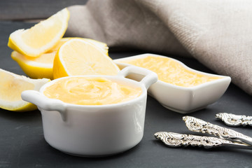 Lemin curd in a white jar over grey background