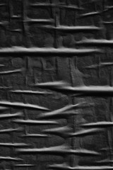 Dark black grey creased crumpled paper background surface old torn ripped posters scary grunge texture backdrop   
