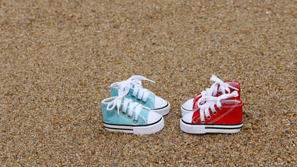 The red and blue sneakers on the sand.