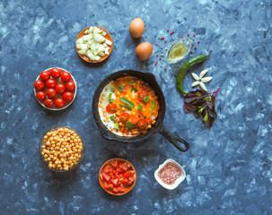 Scrambled eggs with chickpeas and tomatoes on an old pan