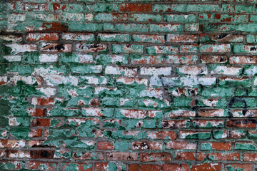 The old wall of brick blocks with traces of paint of different colors.