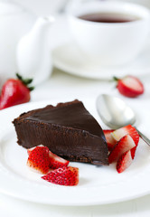 Piece of chocolate cake served with strawberries