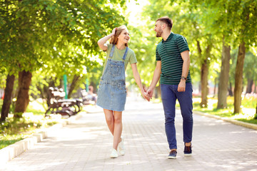 Obraz premium Happy young couple in green park on sunny spring day