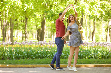 Obraz premium Happy young couple in green park on sunny spring day