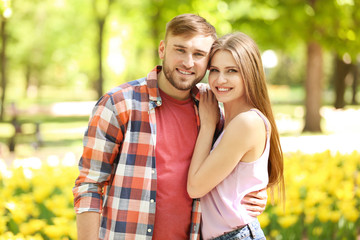 Fototapeta premium Happy young couple in green park on sunny spring day